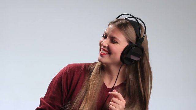 Joyful woman listening music in headphones