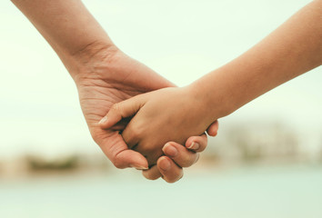 Mother holding hand of her daughter. - obrazy, fototapety, plakaty