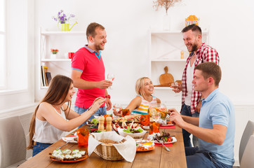 Group of happy people at festive table dinner party
