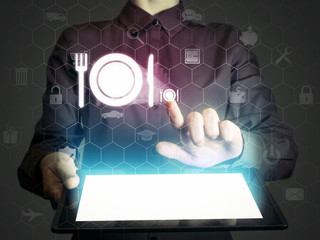 Image of a girl with tablet in her hands and food restaurant icon. She looking menus, ordering food delivery, rate restaurant with using online services.