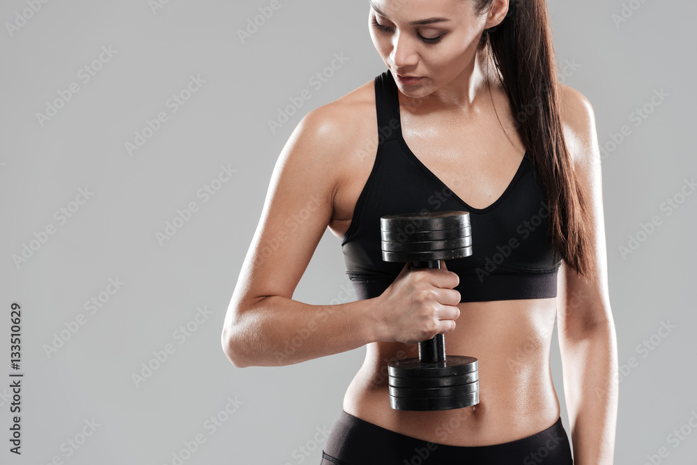 Wall mural sporting woman using dumbbell