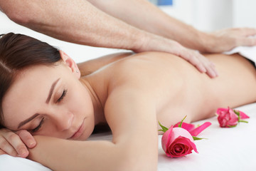 Obraz na płótnie Canvas Beautiful woman receiving a relaxing back massage at spa.