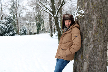 Mann in Winterlandschaft am Baum