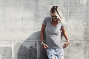 Hipster girl in gray t-shirt over street wall