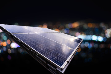 Solar panel with city night light bokeh.
