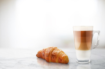 Fresh croissant and coffee on marble table