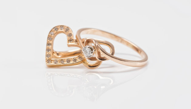 Gold earrings in the shape of a heart and a thin ring with diamo