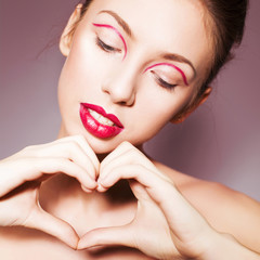 Beautiful brunette woman with red full lips and red lines on her eyelids and braid hairstyle