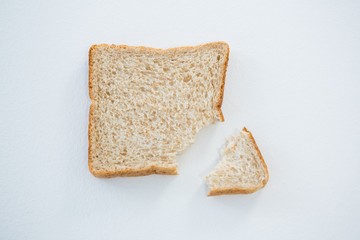 Bread slice with broken edge on white background