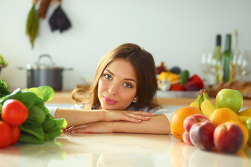 Young woman standing near desk in the kitchen