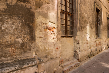 Fototapeta na wymiar Damaged wall and windows. Old cement and bricks. Decades go by.