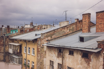 Fototapeta na wymiar Old brick buildings. Rooftops and gloomy sky. Every street has its history.