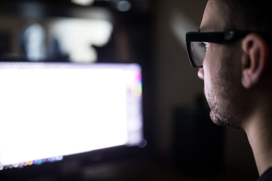 Programer face over white monitor screen on back