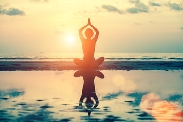 Yoga silhouette. Meditation girl on the background of sea during sunset. Fitness and healthy lifestyle.