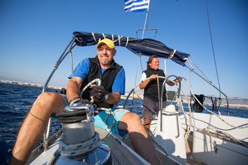 Équipe masculine sur le yacht pendant les courses de voile en mer. Voile, sports extrêmes, loisirs de luxe et mode de vie sain.