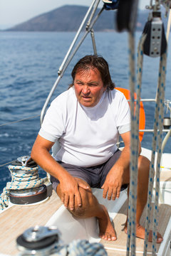 A man sits on his sailing yacht.