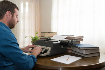 Hombre joven usando una máquina de escribir