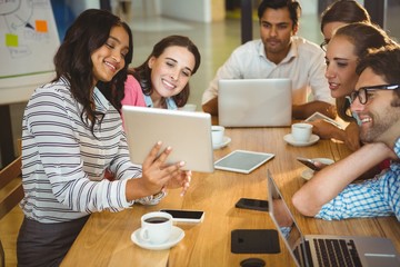 Business executives using digital tablet during meeting