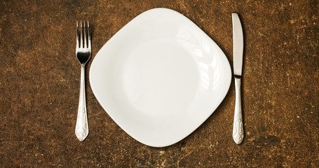 Table setting with fork, knife on a dark background. The view from the top.