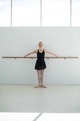 Ballerina practicing ballet moves at barre 