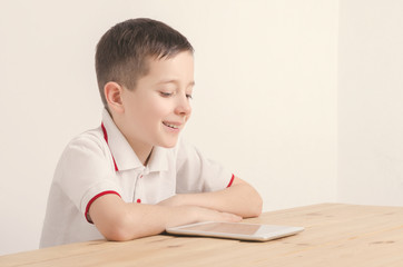 Naklejka premium Boy and tablet. Looking at the screen.