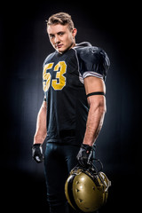 American football player holding helmet