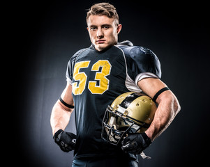 American football player holding helmet