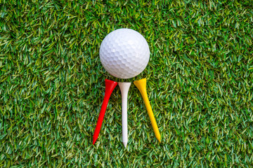 golf ball and tee on grass