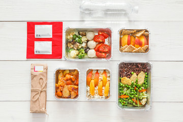 Healthy food take away in boxes, top view at wood