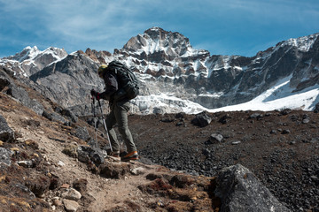 Man with Backpack walking up along sharp Ridge