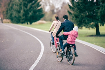 Fototapeta premium Family riding bicycles in park