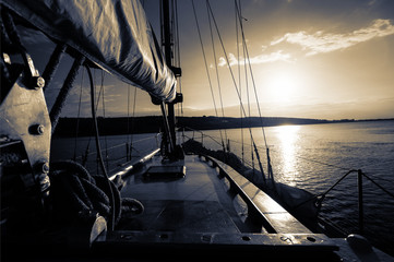 Naklejka na ściany i meble sunset at sea on aboard Yacht Sailing