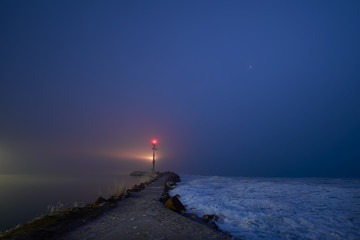 Small lighthouse in the lake at night