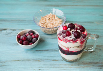 smoothie with berries, strawberries, raspberries, strawberries with yogurt and muesli on turquoise, wooden background.