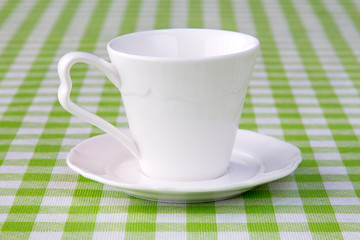 Empty cup on the checkered tablecloth