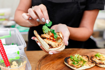Street vendor hands making taco outdoors