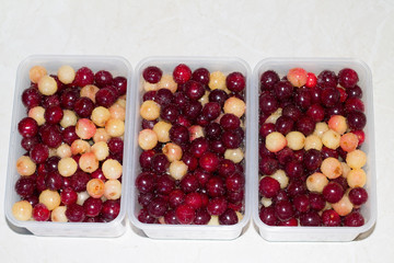 Red and white ripe cherry in a plate on a white background