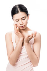Woman applying facial moisturizer cream for sensitive skin