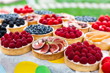 Fruit and berry tarts dessert tray assorted outdoors