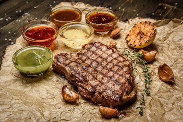 grilled steak with different sauces, on parchment. vertical top view