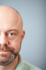 Facial close up of a half of a bearded middle-aged man