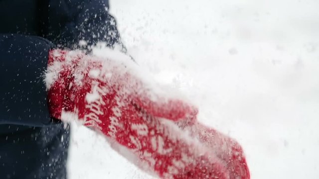 girl in red mittens shakes off the snow in winter