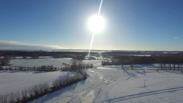 aerial view  fly over beautiful snowy landscape with sun and blue sky in germany - dronen flight