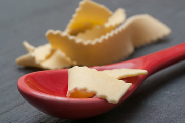 Pâtes fraiches et petite cuillère rouge sur fond en ardoise