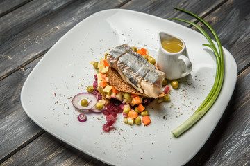 vegetable salad with herring  olive oil on wooden background