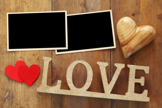 empty photo frames next word LOVE from wooden letters