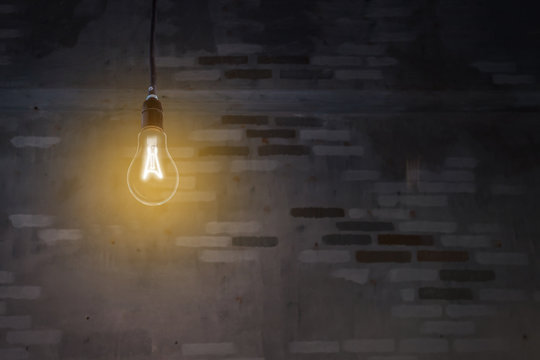 The bulb illuminated in the dark with brick background