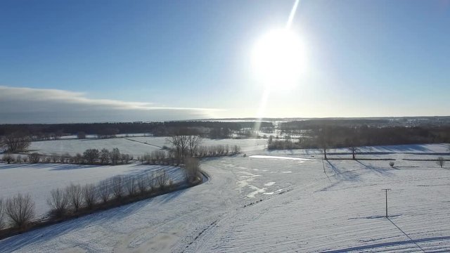 aerial view  fly over beautiful snowy landscape with sun and blue sky in germany - dronen flight
