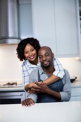 Portrait of couple embracing each other in kitchen