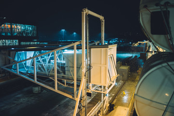 Passenger ferry jet bridge by snowy evening